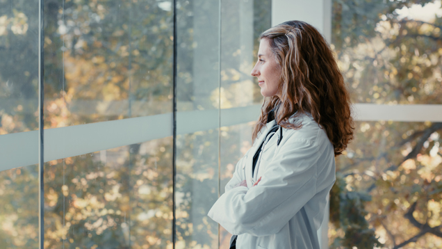 MD lady thoughtful looking through a big glass window
