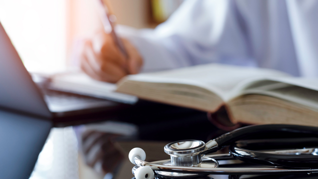 Medical student writing at desk learning