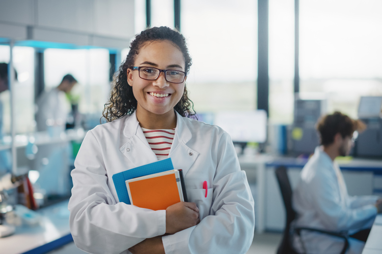 Osteopathic student holding books on lab