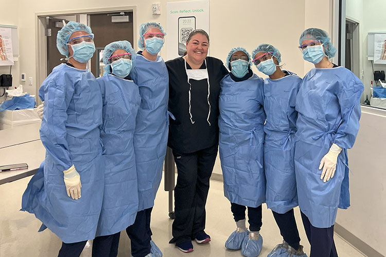 Physician Assistant Students and Professor Pose in Clinical Setting