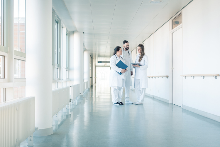 Physician assistant on hospital hallway speaking