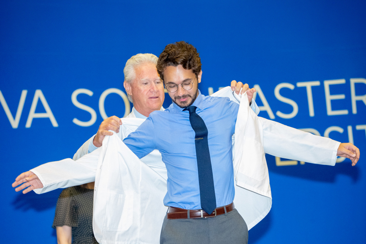 Putting white coat to student at ceremony