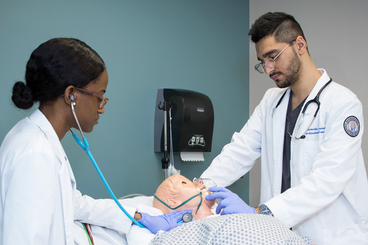 Respiratory therapy students practicing with medical mannequin