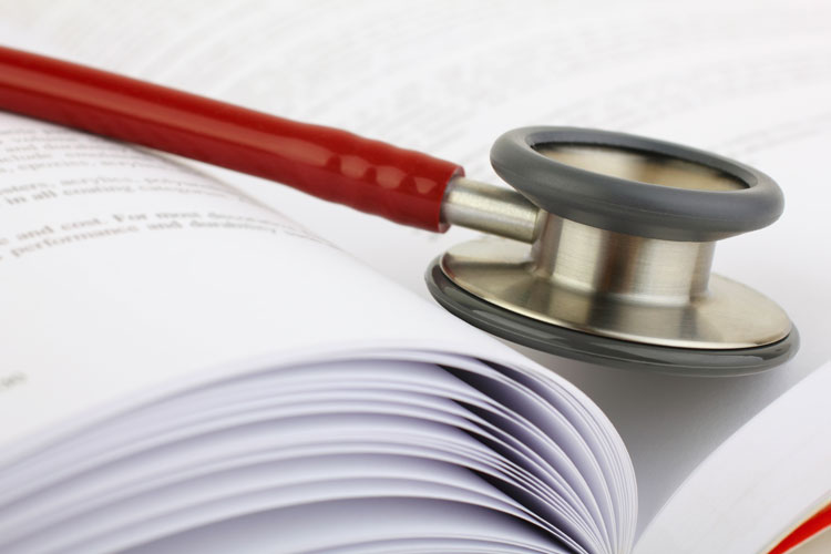 Stethoscope on book with medical teaching concept closeup