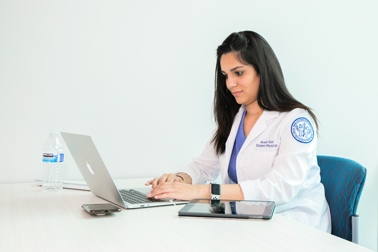 Student physician studying in a laptop computer