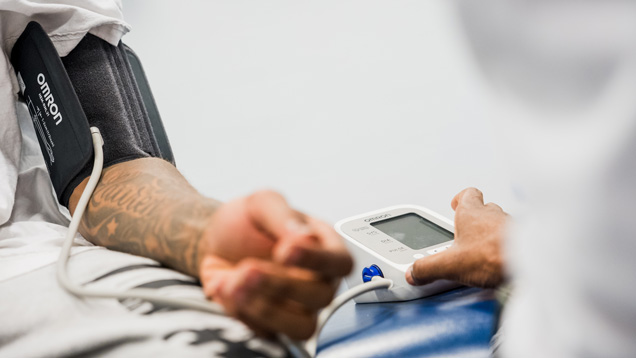 Doctor taking blood pressure with digital machine