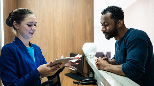 Man scheduling screening appointment at front desk