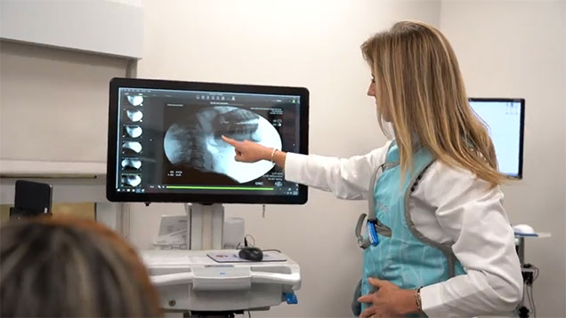 Person pointing at monitor showing X-ray