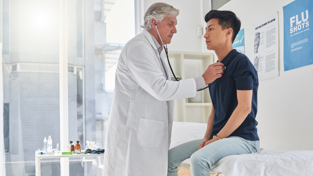 Student getting medical physical exam by doctor