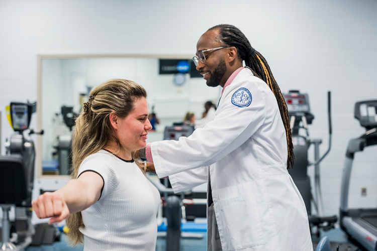 Dr. Joseph checking posture on patient for sports medicine