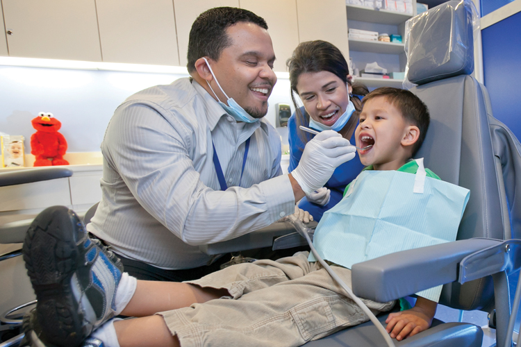 Pediatric dentist checking teeth health on child