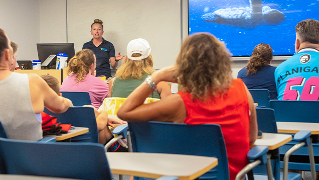 Group of people watching a presentation about sea turtles