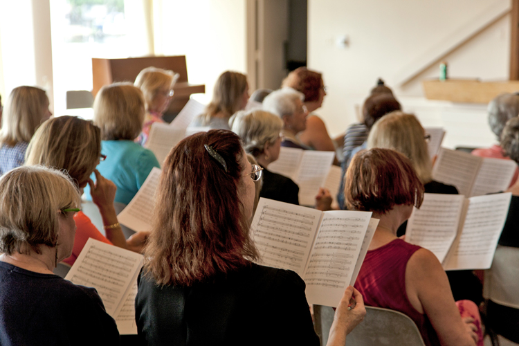Singers at practice reading paper