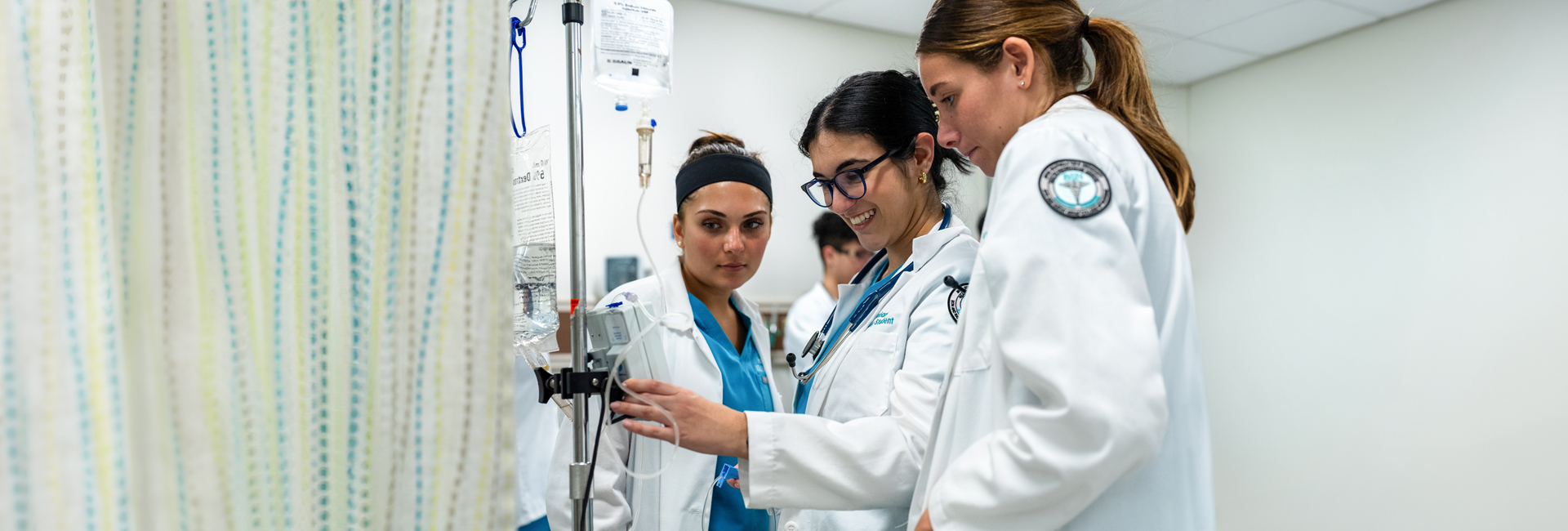 Three nursing students practicing in the lab