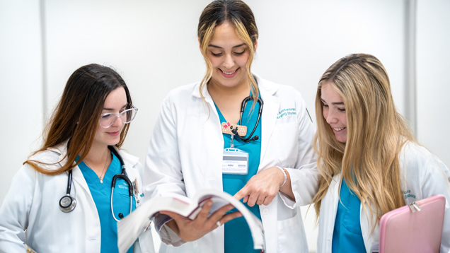 Group of nursing students reading book