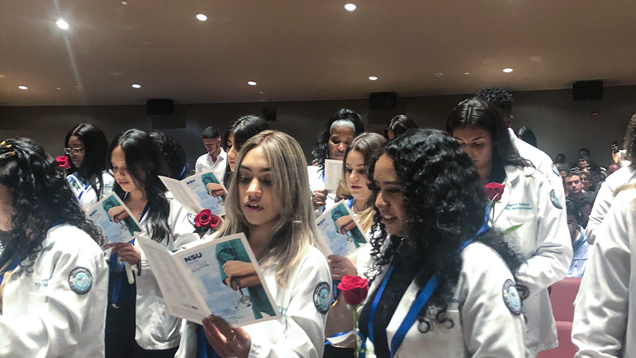 People in audience reading booklet at pinning ceremony