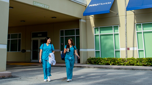 Two female students walking around NSU campus outdoors