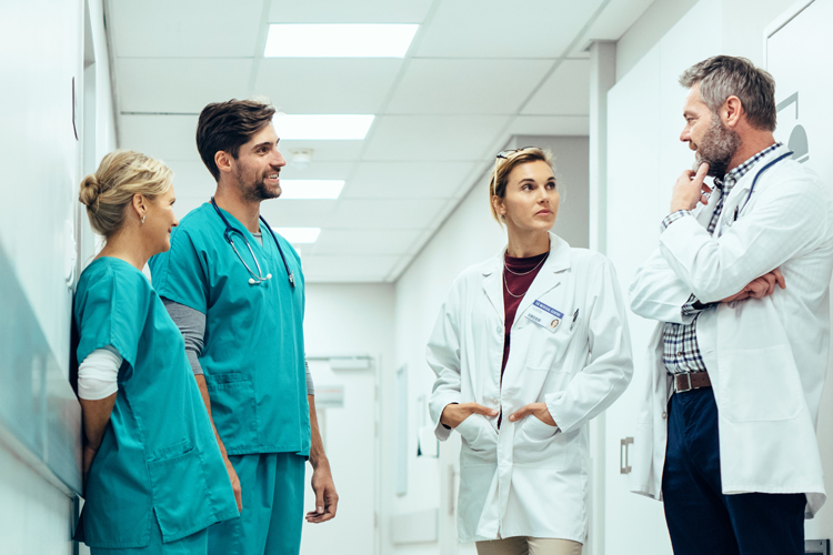 Group of four medical professionals in a hallway of a hospital.