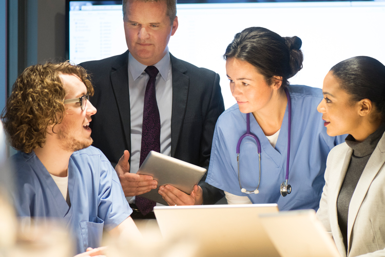 Group of health care professionals using laptops in meeting
