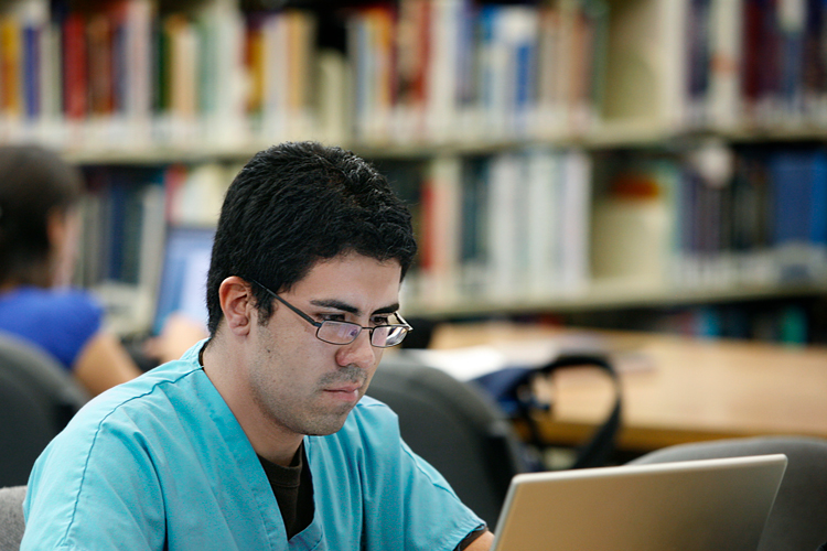 Male student concentrated looking at laptop screen
