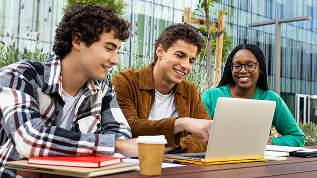 Group of students using a laptop outdoors