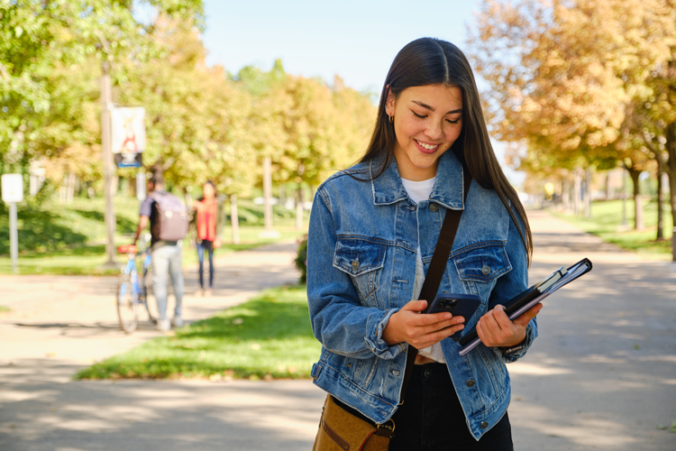 Student smiling looking at the cell phone
