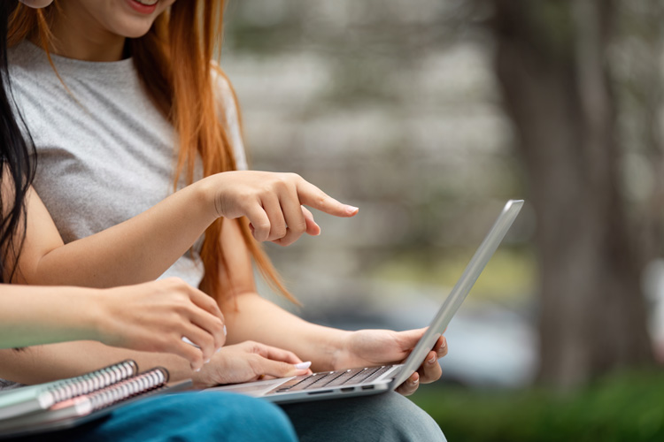 Students pointing to laptop information