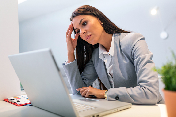 Woman worried while using a laptop at work