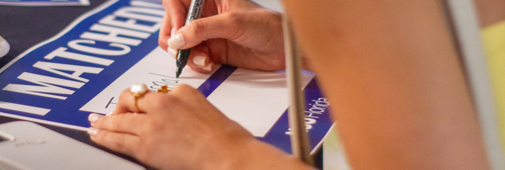 Group of faculty and students viewing monitor while student uses virtual reality goggles.