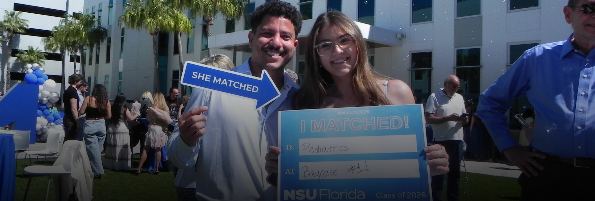 Group of faculty and students viewing monitor while student uses virtual reality goggles.