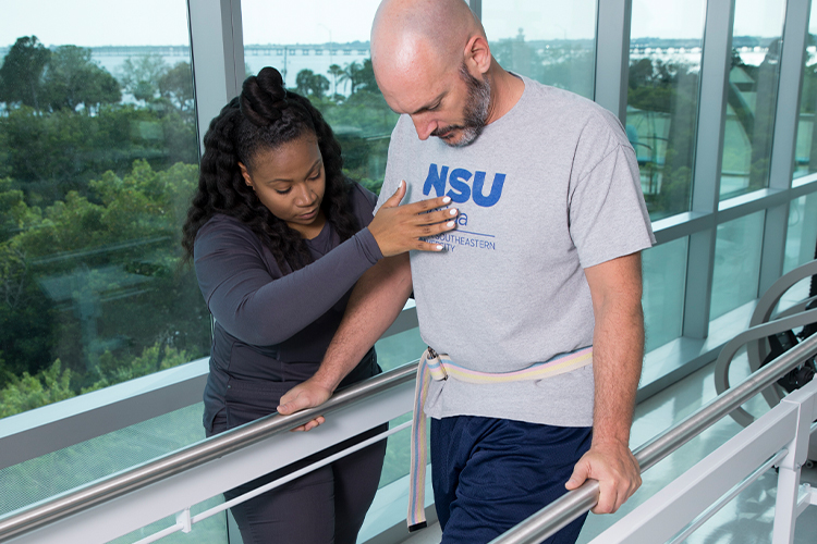 Physical therapist helping a patient walk
