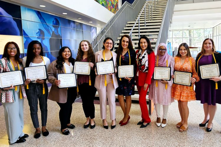 Students Holding Certificates Pose with Professor