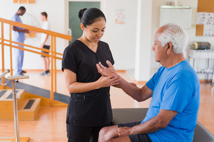 Therapist examining the arm of a patient