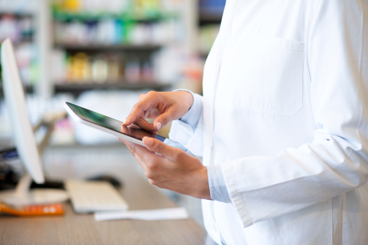 Pharmacist staying up to-date with newsletter using tablet