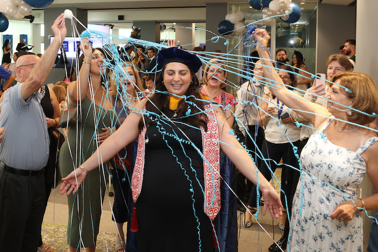 Graduate being showered with confetti.