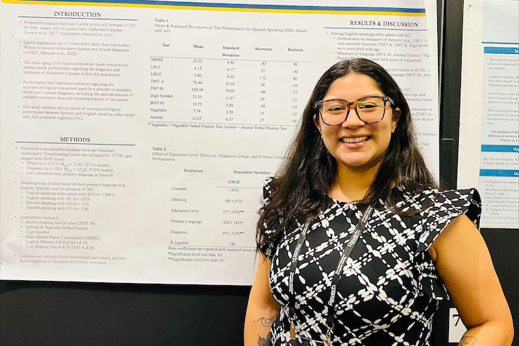 Student standing in front of poster presentation at NAN Conference.