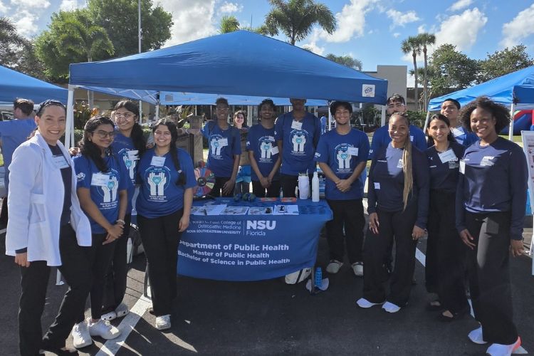 Public health students under a blue tent
