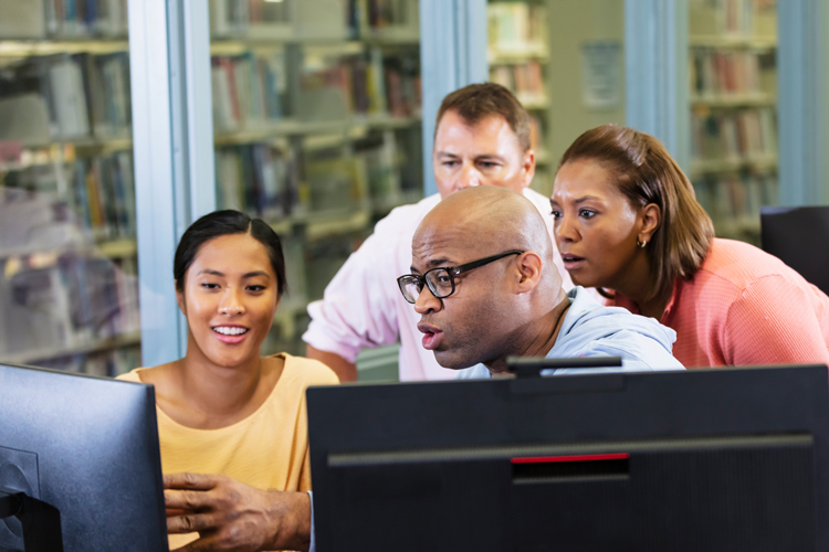 Faculty looking at screen for support scholarship