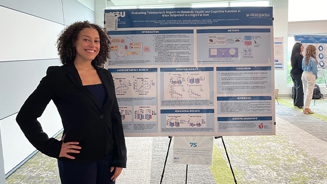 Julianna Bonetti standing next to her research presentation