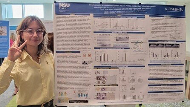 Maria Castellon standing next to her research presentation
