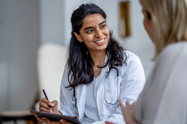 Doctor speaking to her patient and taking notes