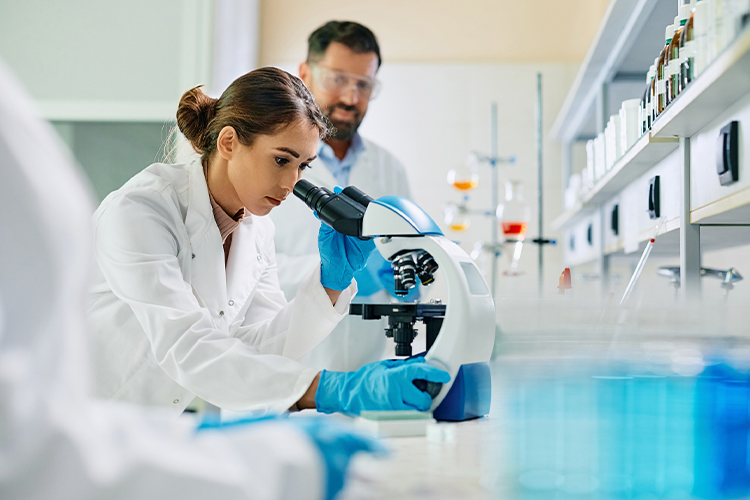 Scientist using microscope during her research in a lab