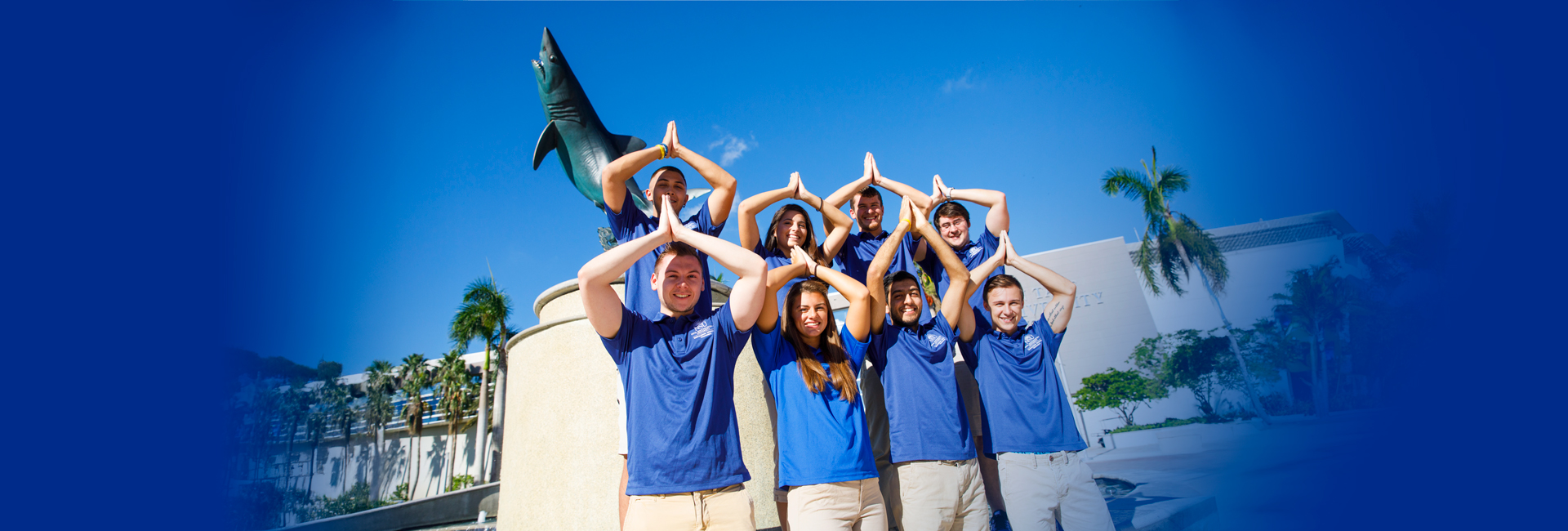 Students in front of shark fountain doing fins up