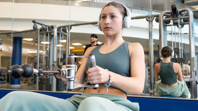 Student at the gym using cable machine