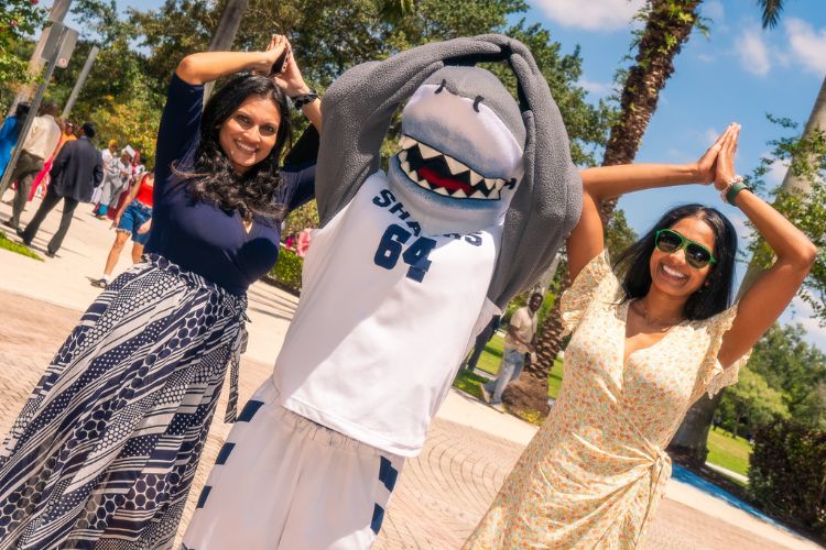 NSU student making fins up sign with razor mascot