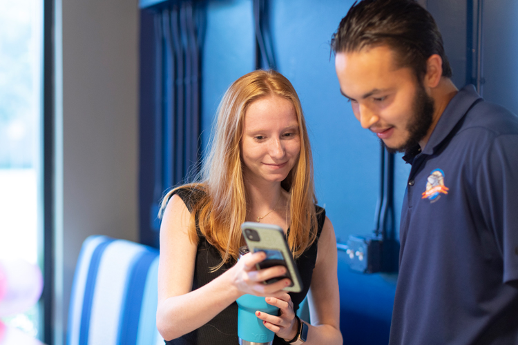 Student showing phone to another student