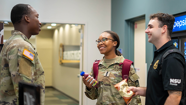 Group of NSU students in United States Army uniform talking in the hallway