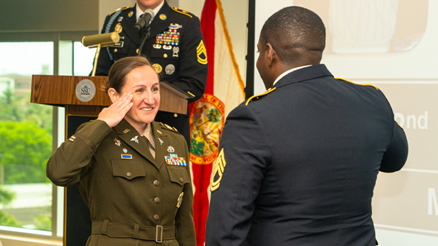Two veterans saluting each other in a ceremony