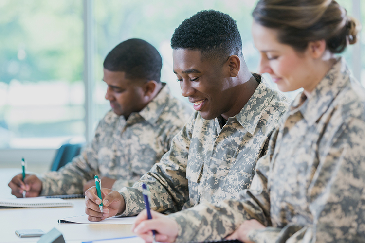 Group of military cadets writing in notebooks
