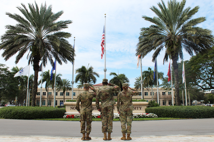 Veterans at service plaza doing salute